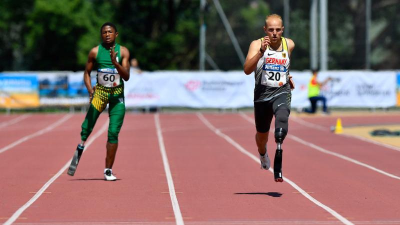 Two male sprinters with prosthesis race side by side