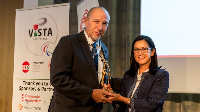 Woman presents man with award