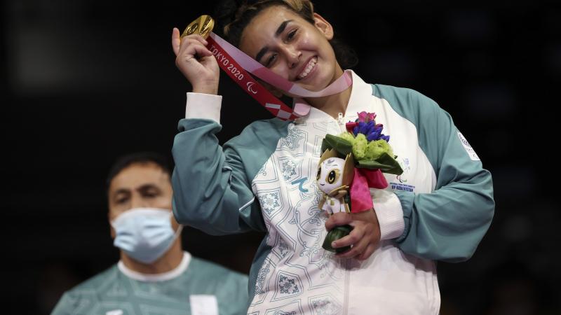 Guljonoy Naimova smiles as she celebrates with her gold medal