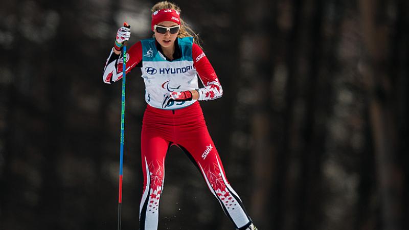 A standing woman competing in Para cross-country skiing