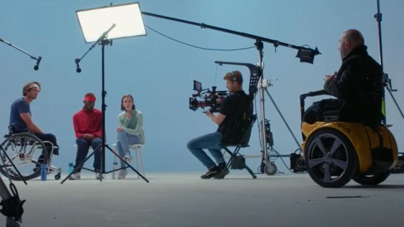 A male athlete on a wheelchair is filmed by a production crew