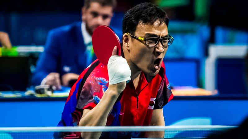 A male Para table tennis player prepares to return the ball.