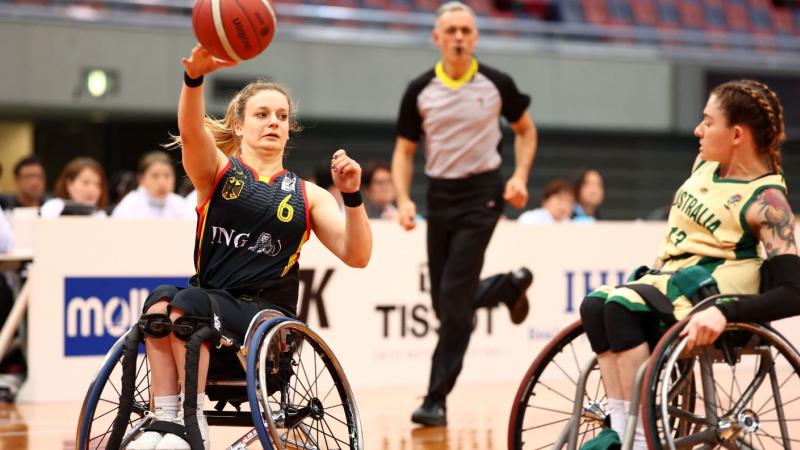 A female wheelchair basketball athlete throws the ball