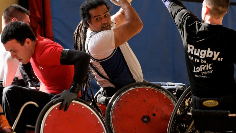 A picture of a man in a wheelchair trying to make a pass with a ball.