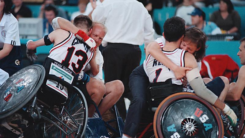 A picture of a man in a wheelchair and a girl celebrating a victory.