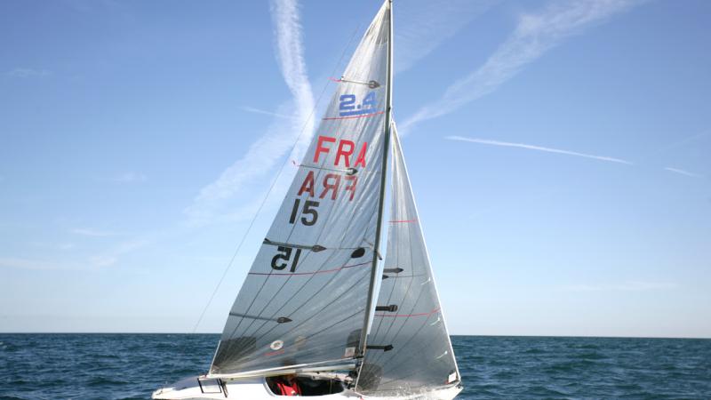 Man inside sailing boat with FRA and 15 written on the sail