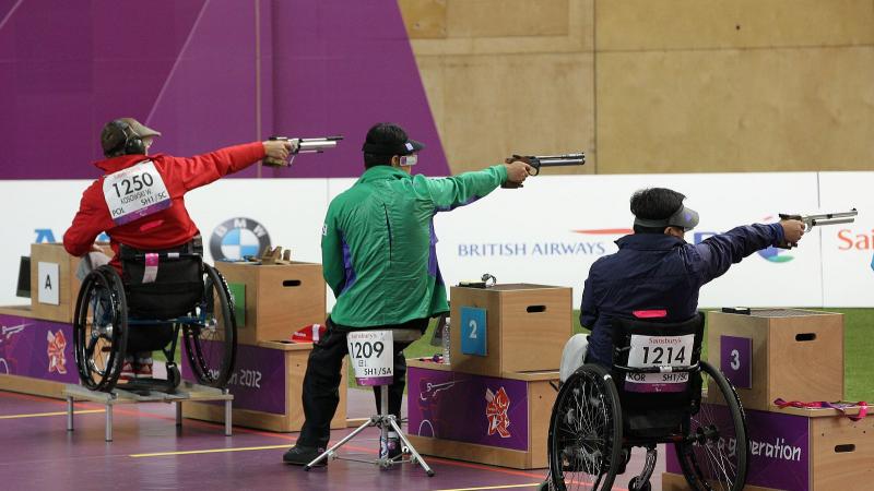 Three athletes shooting in a range