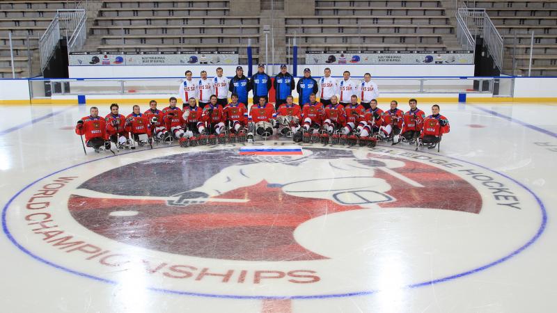Ice sledge hockey players and coaches have a team photo