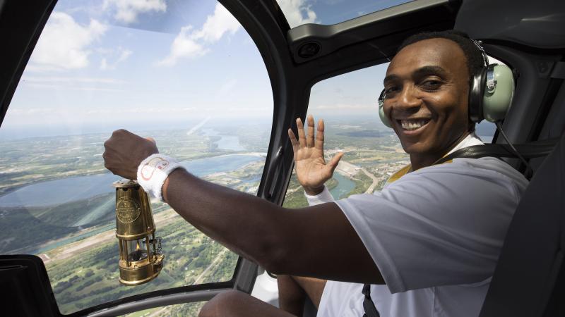 Dwight Drummond, CBC News Toronto co-host, carries the Parapan Am flame on board a helicopter in Niagara Falls, Ontario.