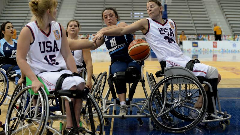 Two women in wheelchairs defending at a basketball game