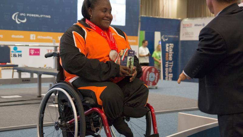 Woman in wheelchar with medal around her neck