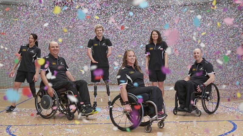 Six people standing and in wheelchairs