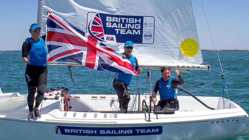 Three people on a boath showing the British flag