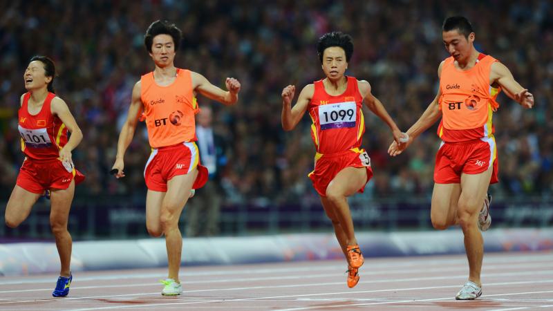 China's Guohua Zhou and her guide Jie Lie cross the line first to win gold ahead of teammates and bronze medalists Daqing Zhou of China and her guide Hui Zhang in the women's 100m T12 Final at the London 2012 Paralympic Games.