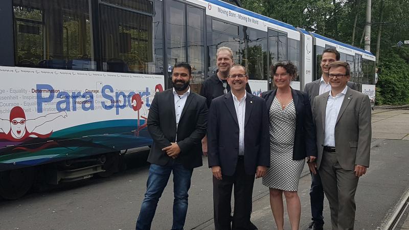 Five people standing in front of a tram in IPC design