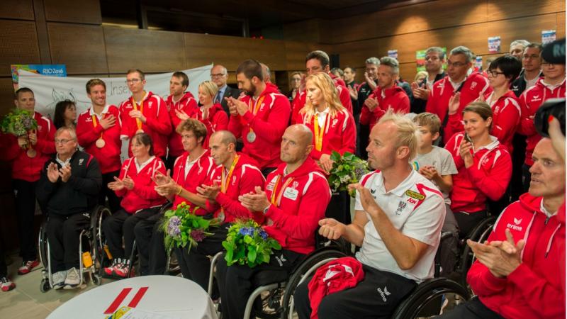 A group of athletes is welcomed by sports dignitaries