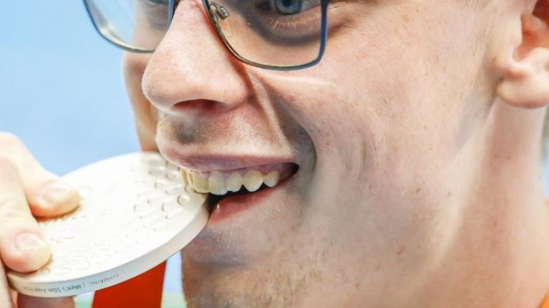 Face of a man biting on a medal