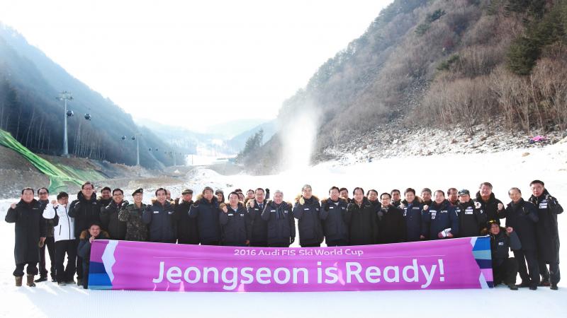 Group of people pose in front of slopes