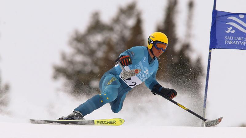 Man with one leg skis down a hill.