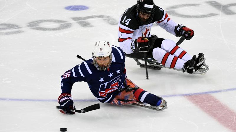 Man on ice hockey sledge makes a move with the puck