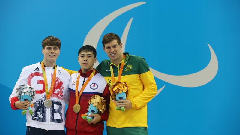 Three male swimmers standing on a podium at Rio 2016