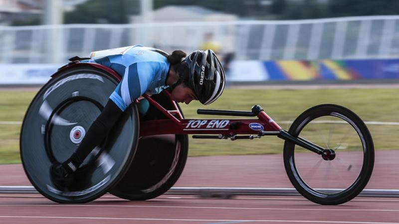 female wheelchair racer on track with head down