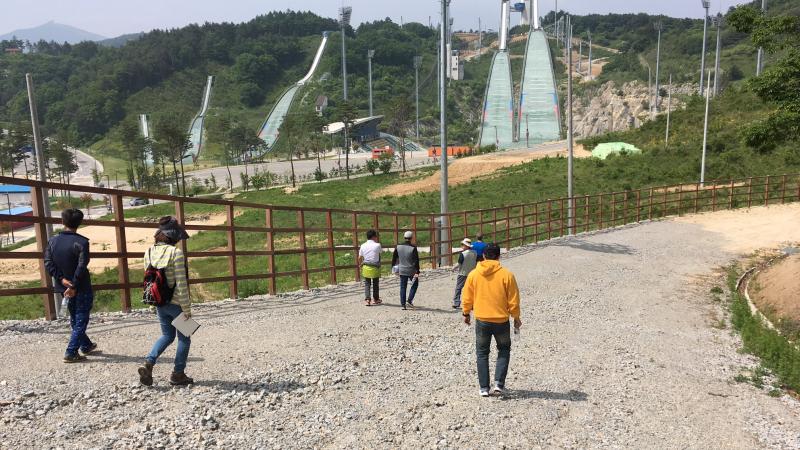 snowless skiing course being inspected by two men