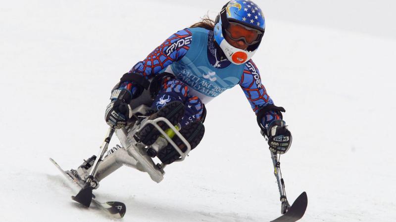 a para alpine skier skies down a slope