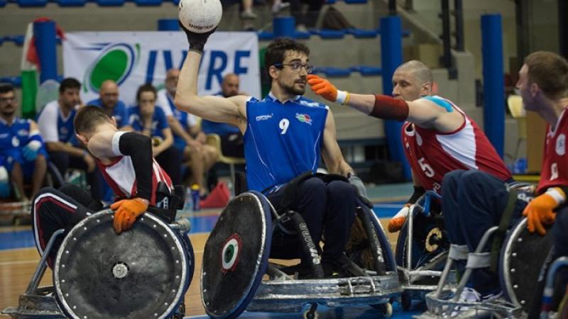 wheelchair rugby players battle for the ball