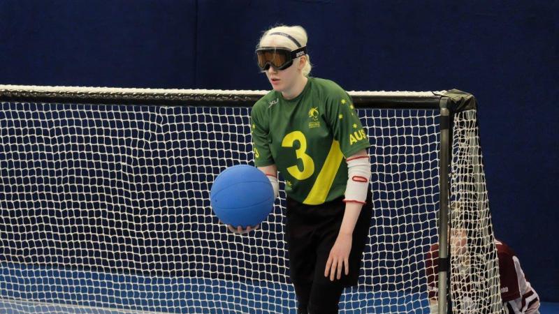 A female goalball player holds the ball