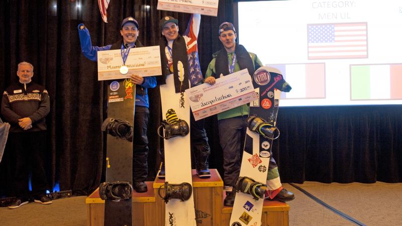 Three male snowboarders on the podium
