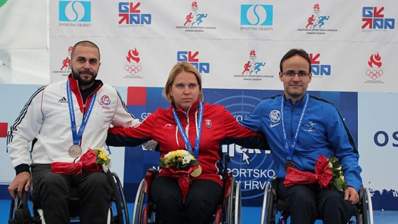 a group of three wheelchair athletes on the podium