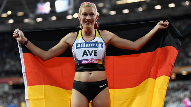 Person smiling and posing with the flag of Germany