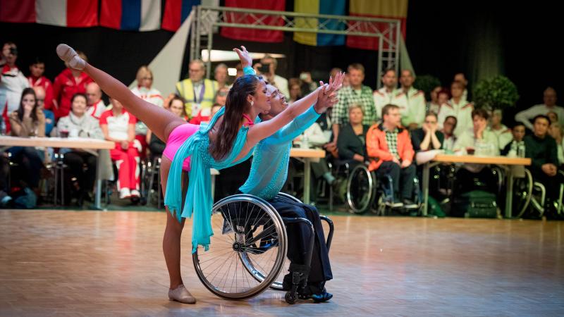 Man in wheelchair and woman standing dancer dance