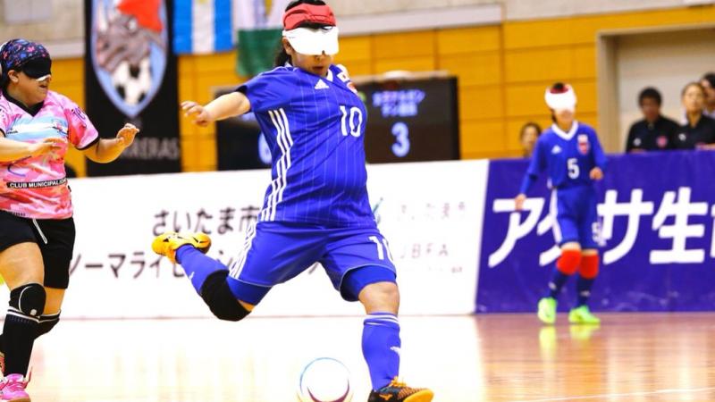 a female blind footballer takes a shot