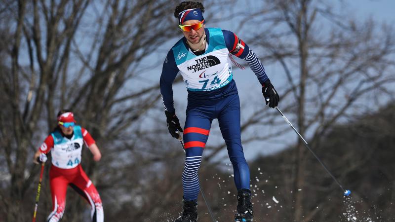 a male biathlete skies through the snow