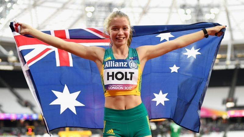 a female Para sprinter holding up the Australian flag