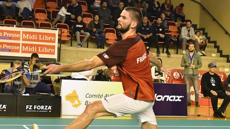 male Para badminton player Lucas Mazur plays a backhand