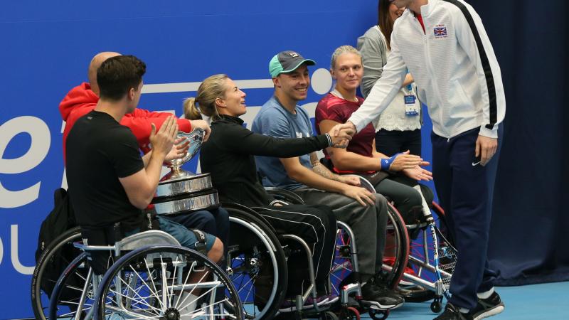 Able bodied tennis player Andy Murray shakes hands with a number of wheelchair tennis players