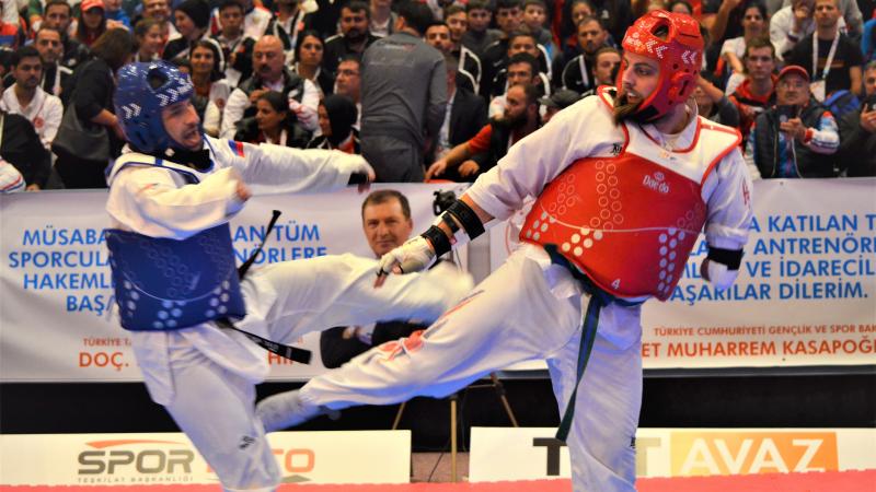 male Para taekwondo fighter Matt Bush kicks another fighter around the legs