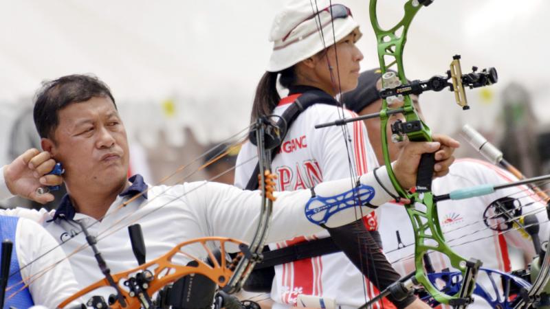 male Para archer Ouk-Soo Lee draws back his bow and prepares to shoot