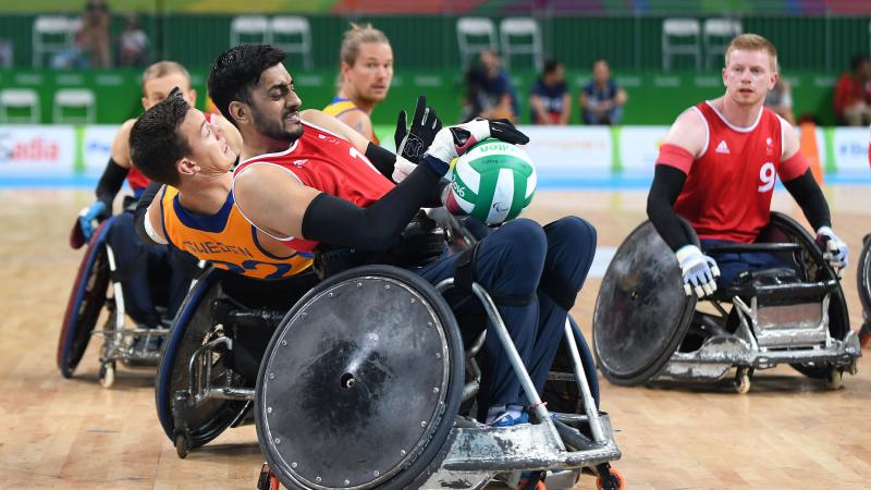 wheelchair rugby players grappling for the ball