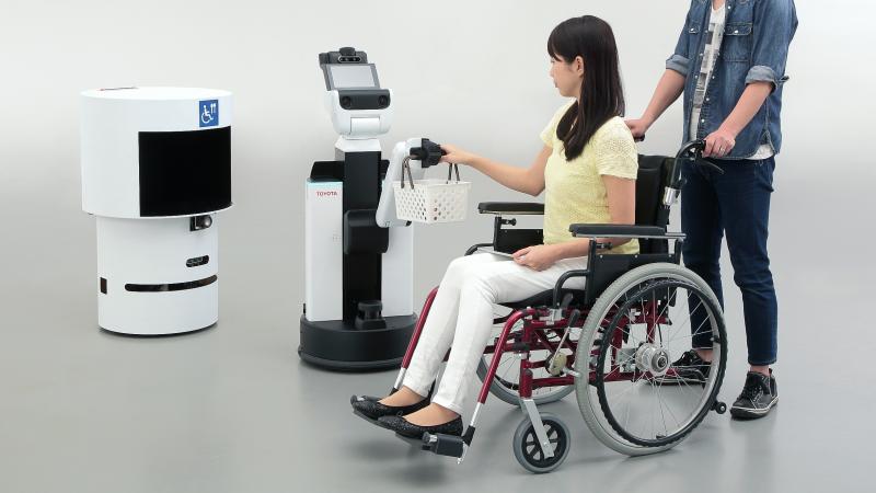 a person in a wheelchair having their basket held by a robot