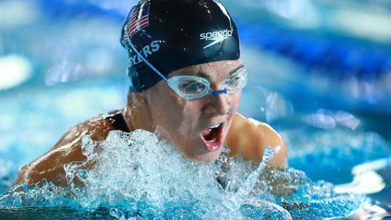 female Para swimmer Rebecca Meyers takes a breath mid-breaststroke