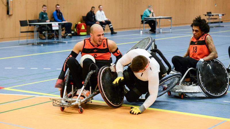 Two men in wheelchair chairs collide playing wheelchair rugby