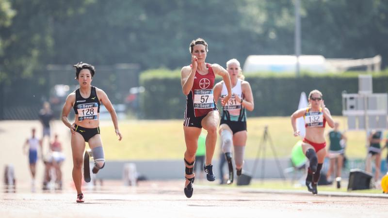 Four female Para athletes running in a track