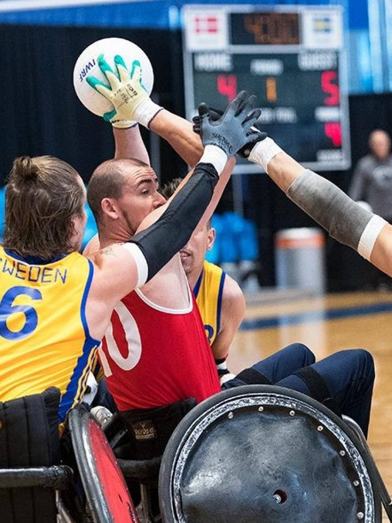 Host of Swedish wheelchair rugby players try to steal ball from Danish player