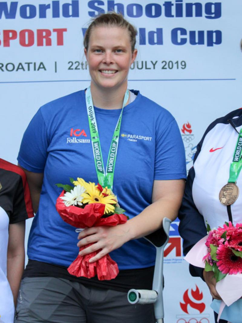 Three female shooting Para sport athletes podium winners pose
