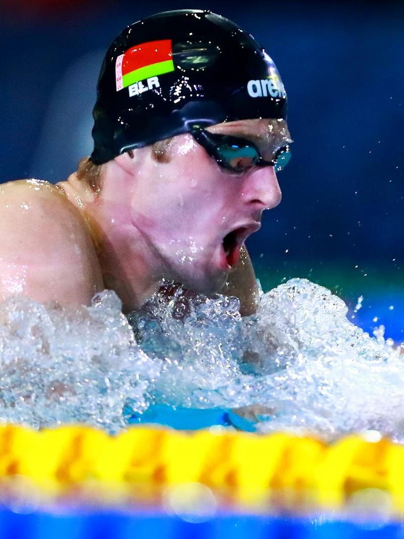 a male Para swimmer takes a breath during a breaststroke