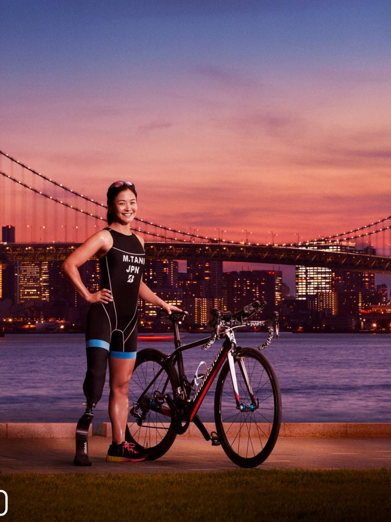 Japanese female triathlete poses with bridge in backdrop